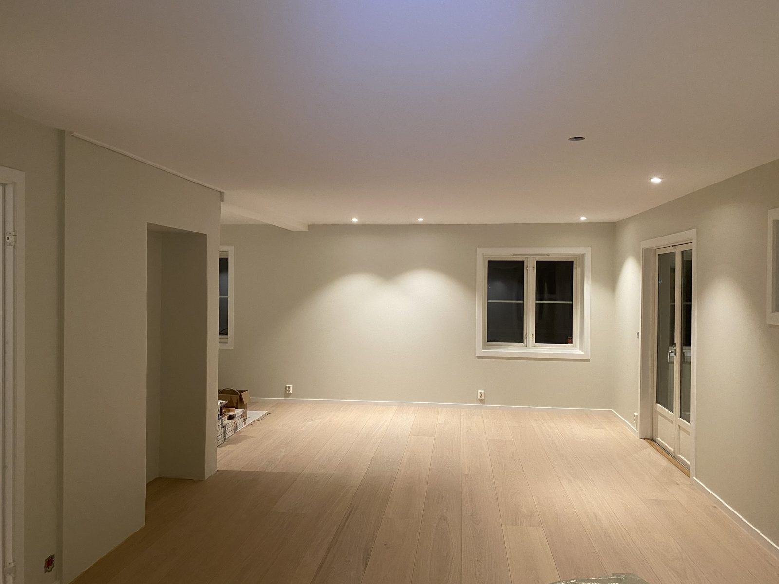 Lyst oppholdsrom med gulv, vegger, tak og dører